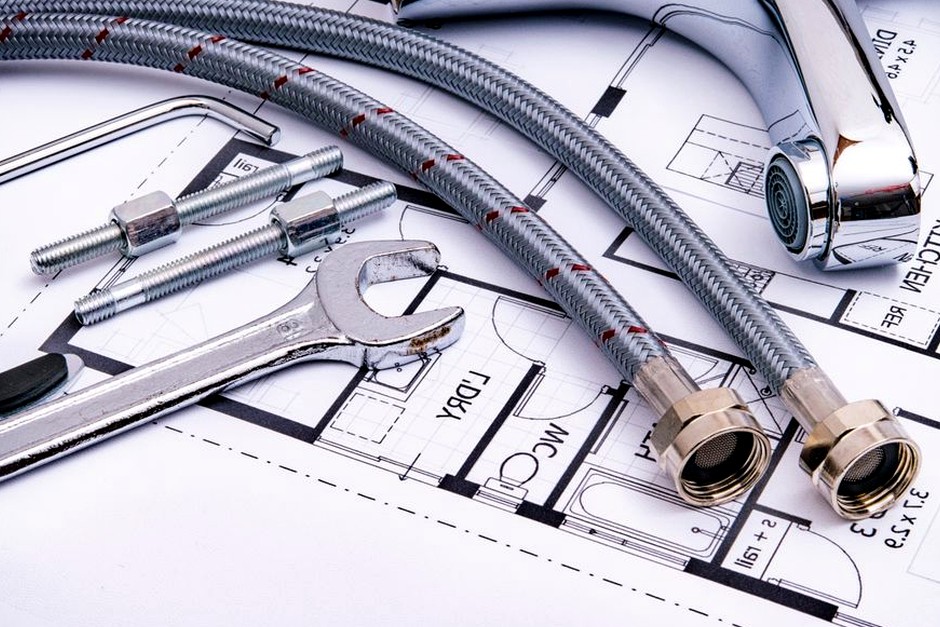 Drafting tools and plans spread across a work surface, reflecting the journal's careful editorial process.