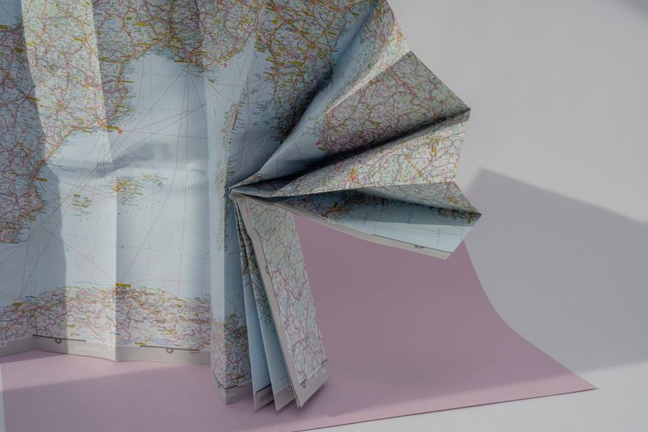 A folded paper map arranged on a table for planning a day trip.