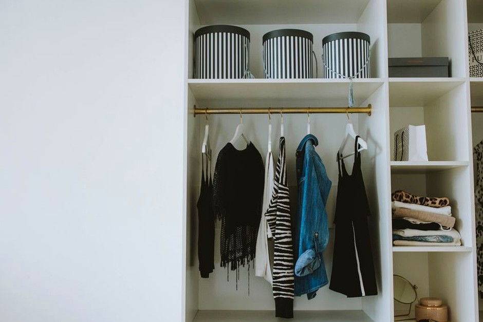 An orderly wardrobe with clothes and storage arranged for a seasonal rotation.